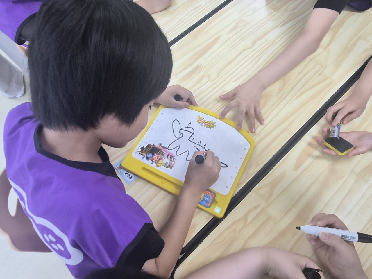 활동지에 그림을 그리는 아이 뒷모습